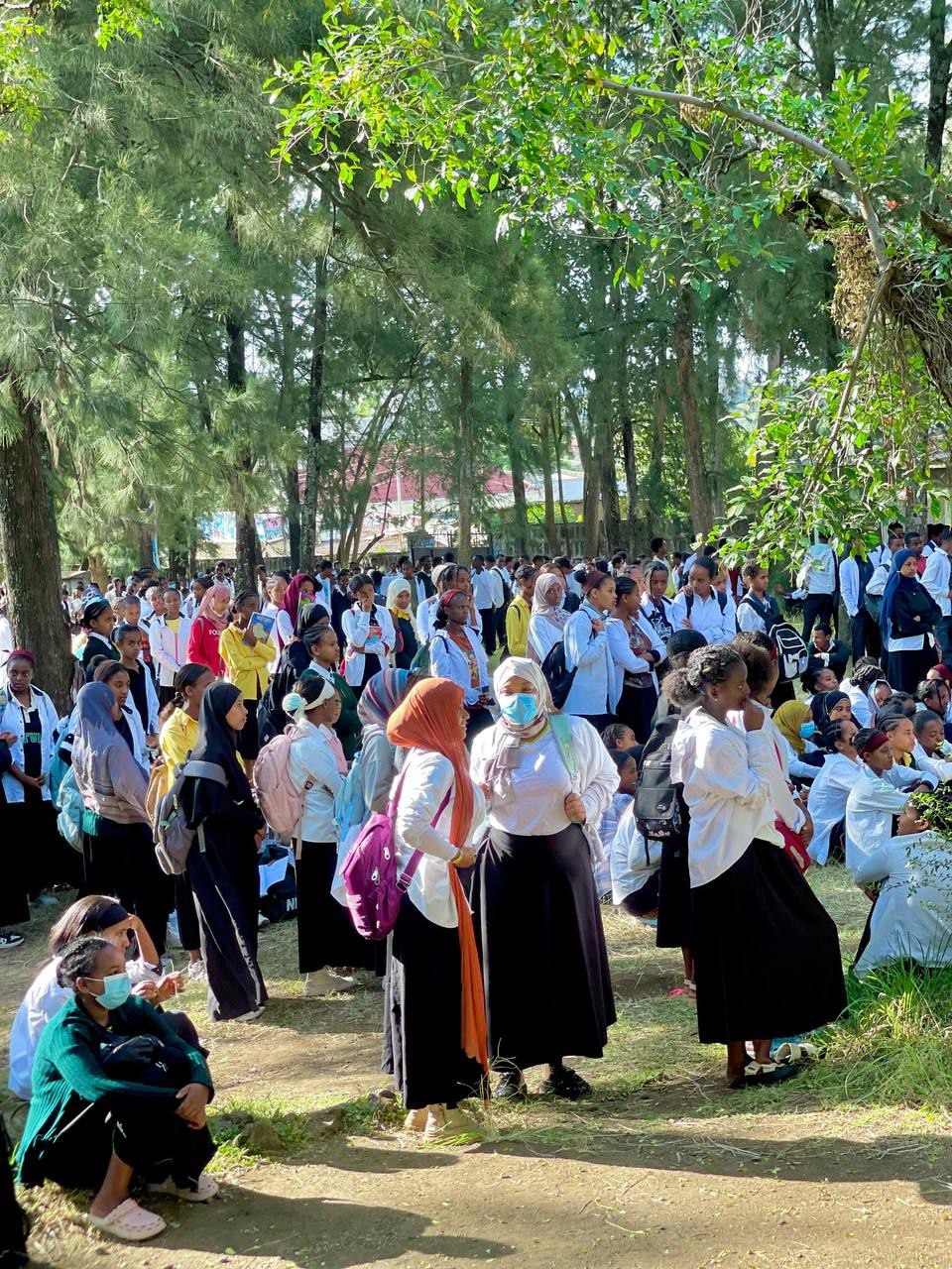 Students gathered outdoors on the school grounds